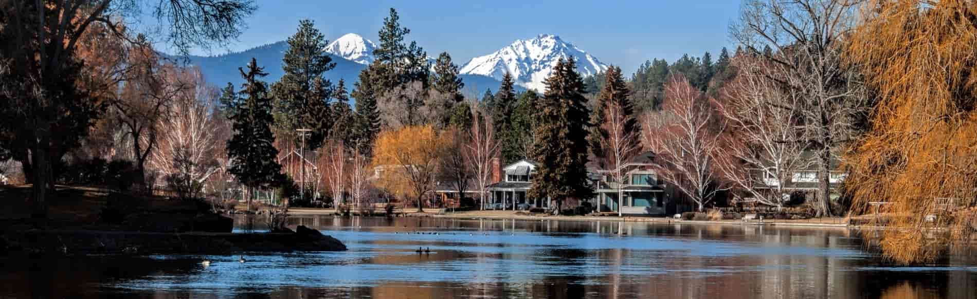 View of Central Oregon mountains with homes overlooking a lake, representing Healthy Home’s Bend office and service area